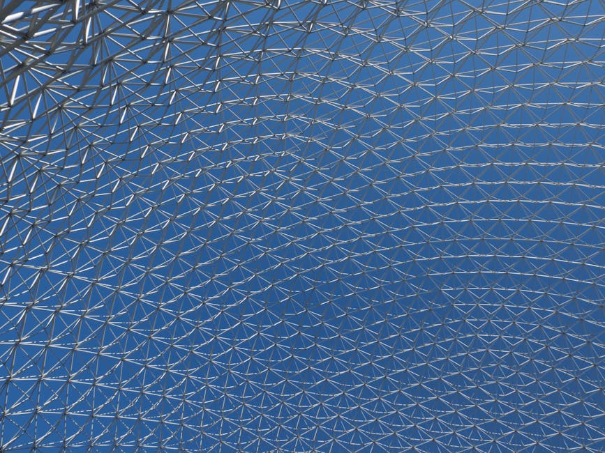 AI Art Hexagon wallpaper pattern — base photo: Close-up of a modern geodesic dome structure with intricate metal patterns against a clear blue sky.