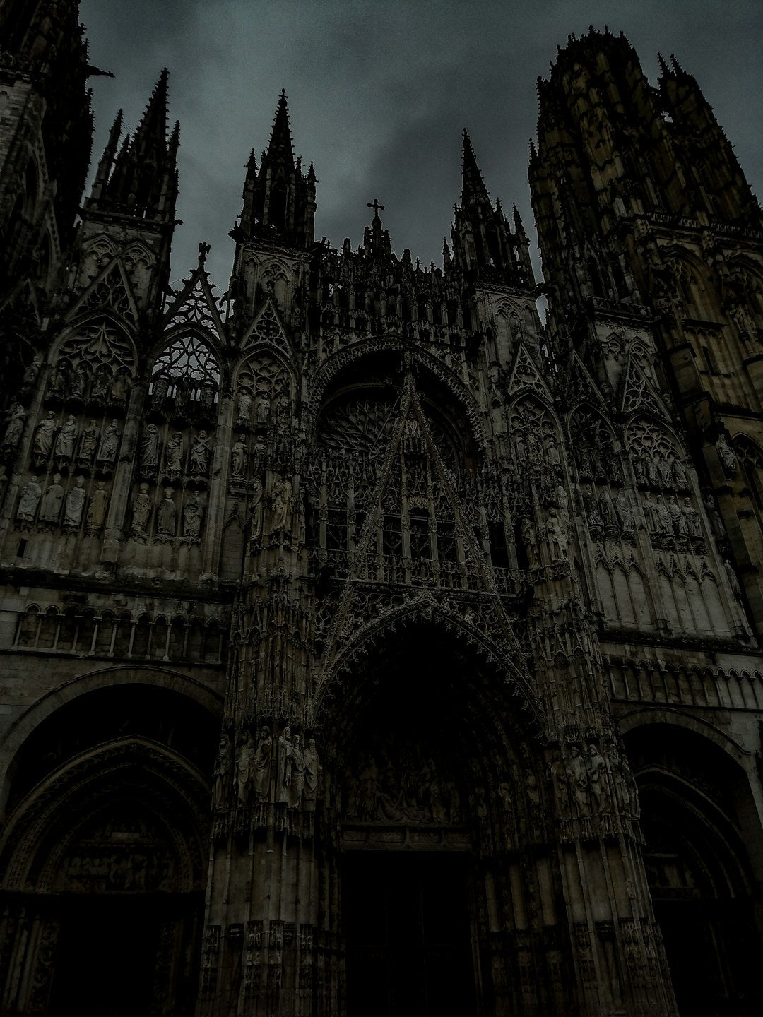 Intricate kaleidoscope pattern with Gothic tracery, inspired by stained glass windows and a dark cathedral sky. — base photo: A striking gothic cathedral silhouetted against a dramatic, dark sky. The architectural details of t