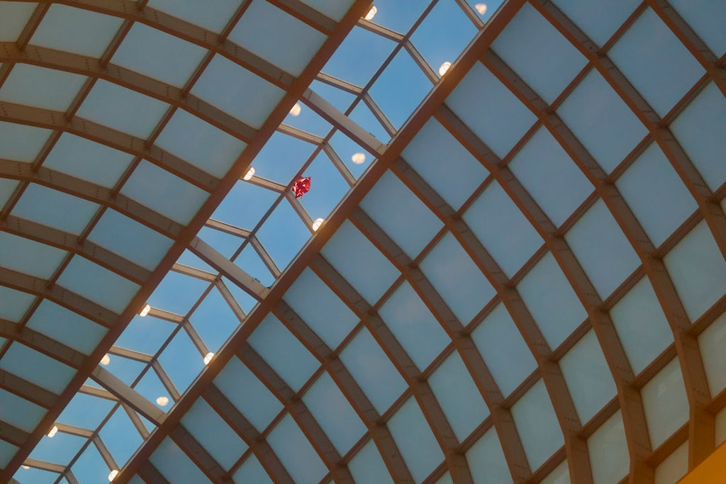Seamless kaleidoscope wallpaper pattern — Stained Glass by wallpaper⁶ — base photo: a red balloon against a blue and orange geometric glass ceiling