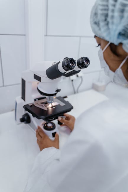 Seamless mirror wallpaper pattern — Medicine by wallpaper⁶ — base photo: Medical professional adjusting a microscope in a laboratory setting.