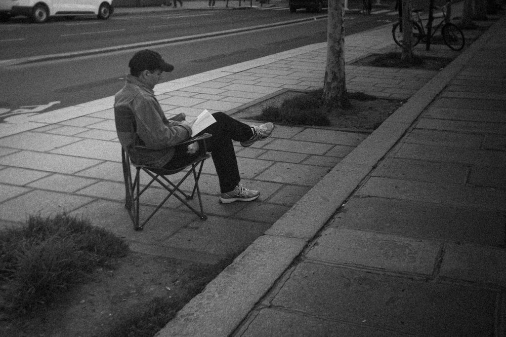 Seamless diamond wallpaper pattern — Origami by wallpaper⁶ — base photo: Man sitting on chair reading a book on sidewalk.