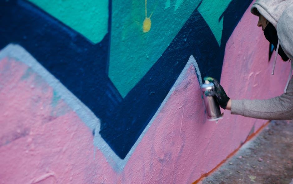 Abstract Kaleidoscope wallpaper pattern — base photo: A street artist spray painting a colorful abstract mural on a concrete wall outdoors.