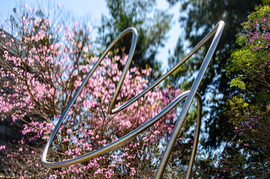 Topology Hexagon wallpaper pattern — base photo: Contemporary steel sculpture with vibrant spring blossoms in a serene outdoor setting.