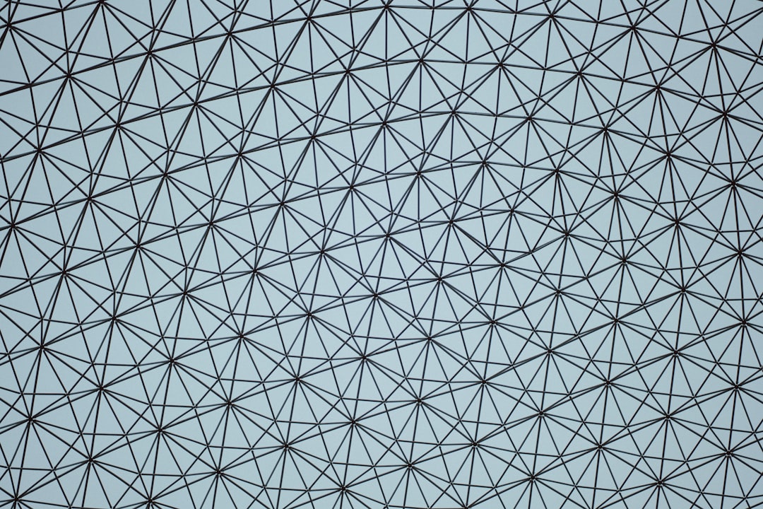 Close-up of a large origami tessellation structure with many lines, showcasing a complex geometric pattern in diamond symmetry. — base photo: A macro view of a large, detailed origami tessellation structure. The complex network of lines and f
