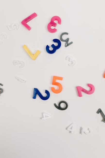 Seamless mirror wallpaper pattern — Arithmetic by wallpaper⁶ — base photo: Brightly colored plastic numbers scattered on a white surface, ideal for educational and creative co