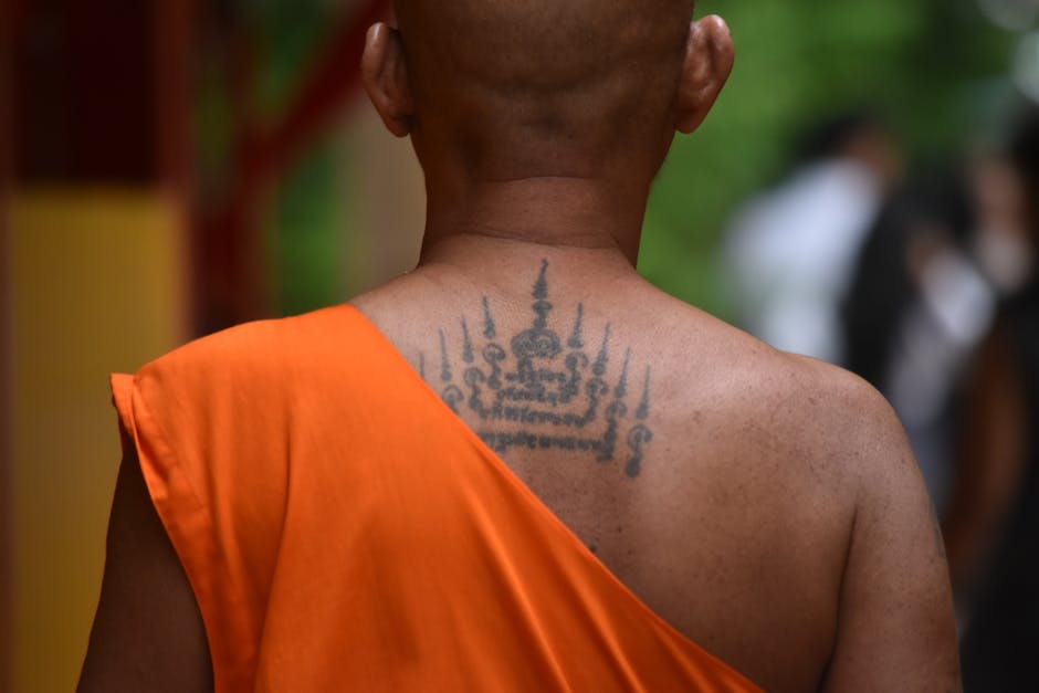 Seamless mirror wallpaper pattern — Calligraphy by wallpaper⁶ — base photo: Thoughtful moment of a tattooed monk amidst spirituality in Bangkok temple.