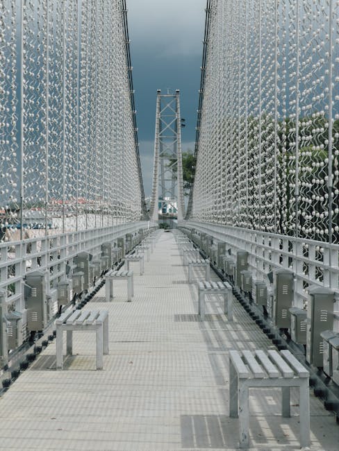 A symmetrical pattern resembling leaded stained glass, created with kaleidoscope symmetry. Geometric shapes and dark lines form an intricate, repeating design. — base photo: A close-up view of modern suspension bridge railing featuring a detailed, geometric pattern reminisc