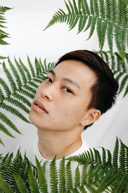 Portraits Hexagon wallpaper pattern — base photo: A contemplative man surrounded by green ferns, captured in natural light.