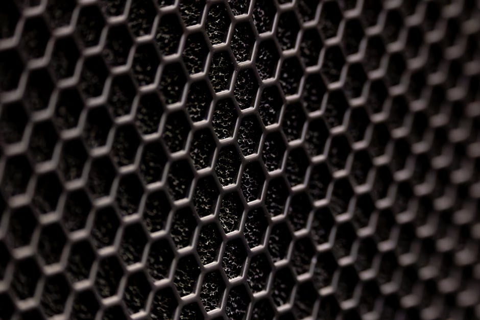 Molecular Physics Kaleidoscope wallpaper pattern — base photo: Detailed close-up of a dark hexagonal metal pattern with a textured surface.