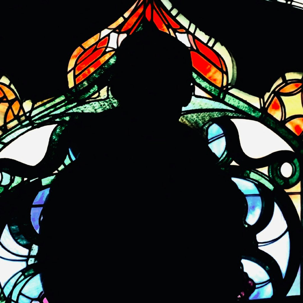 A vibrant stained glass pattern in a hexagonal symmetry mode, featuring deep reds, blues, and yellows with black leaded lines. — base photo: A breathtaking capture by Brett Giesbrecht featuring a dark silhouette contrasted against the vivid,